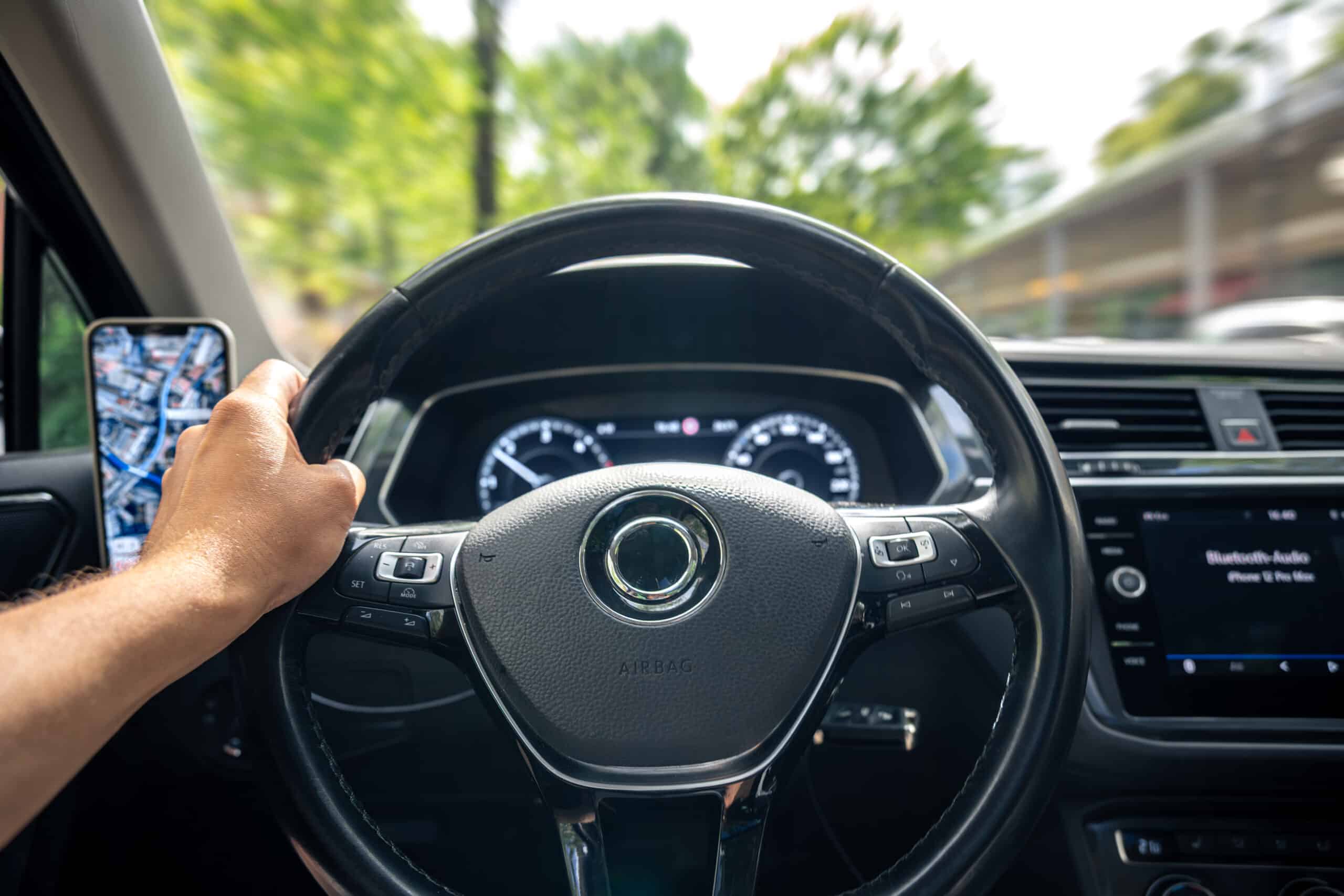 hand steering wheel driving with phone map car navigation view scaled