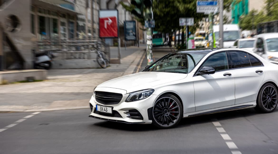 white car turning city street modern urban motion