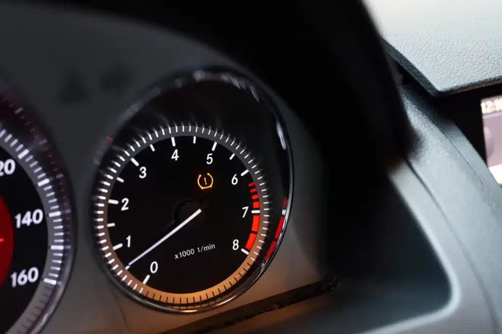 Dashboard display showing tire pressure warning light illuminated, indicating potential low tire pressure, relevant to TPMS diagnostics and vehicle safety.