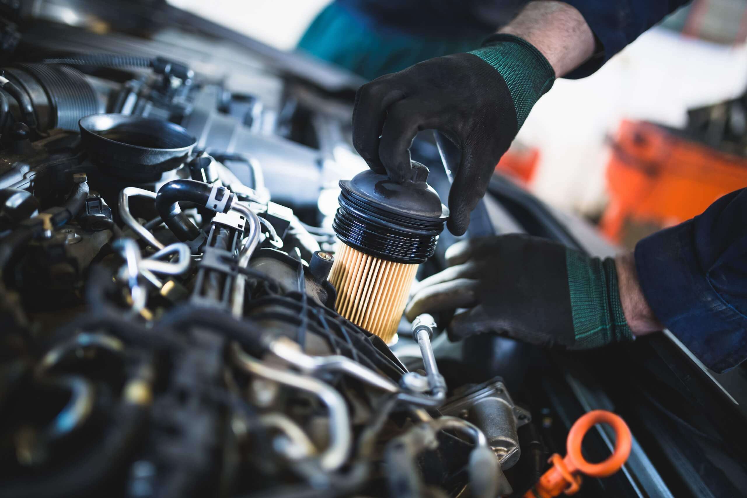 Mechanic replacing oil filter in Volvo engine, emphasizing quality maintenance and service standards at MB Automotive.