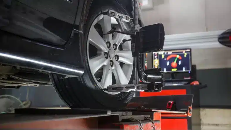 Car wheel alignment service with diagnostic equipment, showcasing automotive repair technology for climate control issues in Suffolk County.