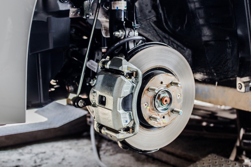 Brake caliper and rotor assembly, showcasing vehicle brake system components for maintenance and repair services at MB Automotive in Bay Shore.