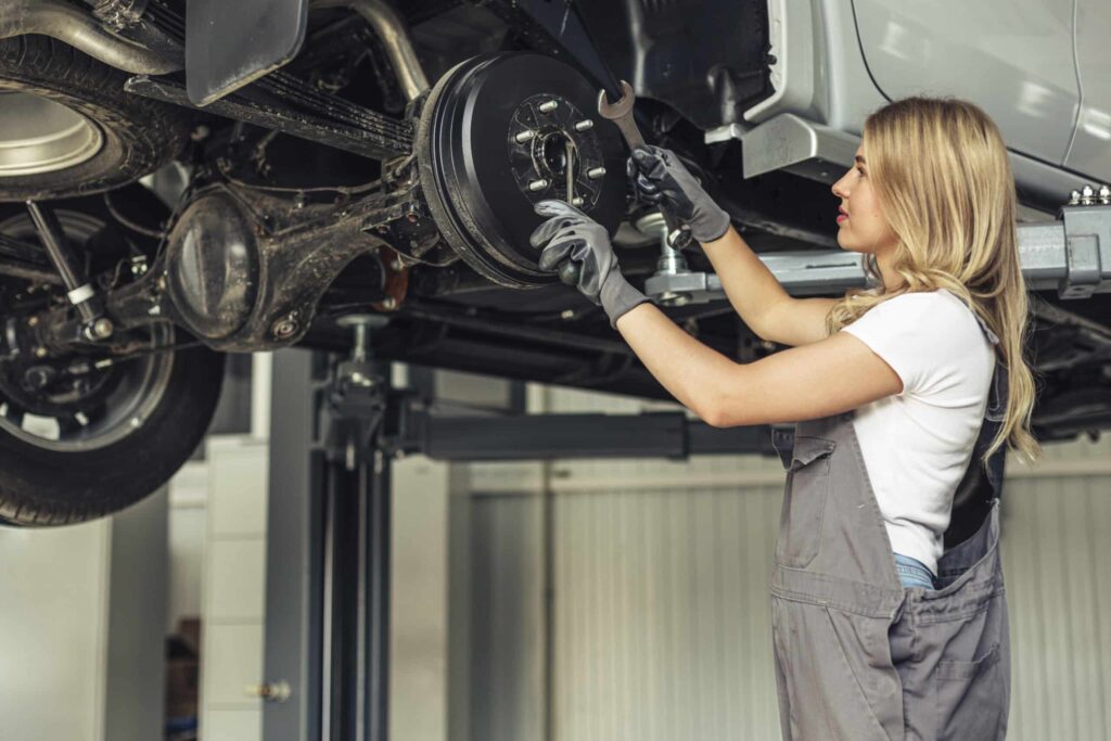 Low angle mechanical woman working on tires
