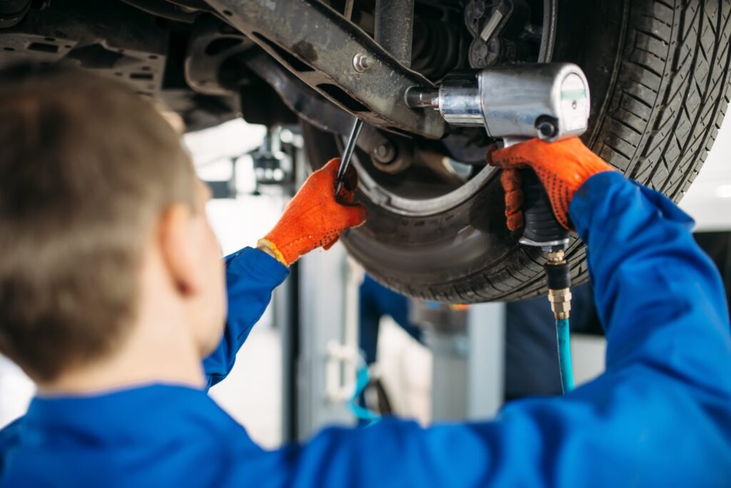 technician with a wrench repair car suspension 2021 08 26 16 26 36 utc scaled 1