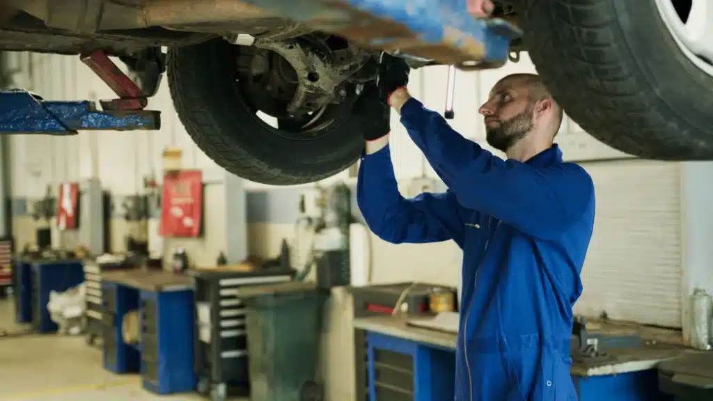 Mechanic in blue uniform working on car maintenance